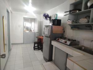 a small kitchen with a refrigerator and a sink at SJ Transient House in San Fernando