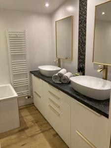 a bathroom with two sinks and a large mirror at Le Tilleul in Pluvigner +30 photos