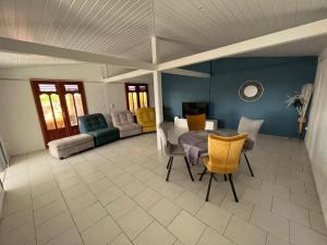 a large living room with a table and chairs at Villa LA SUZANNA in Pointe-Noire