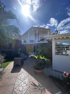 a house with a garage and the sun in the sky at Villa LA SUZANNA in Pointe-Noire