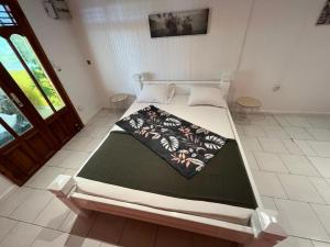 a large bed in a room with a door at Villa LA SUZANNA in Pointe-Noire
