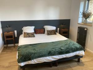 a bedroom with a large bed with white sheets and pillows at Le Tilleul in Pluvigner