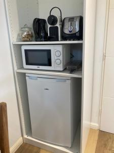 a microwave and a dishwasher in a shelf at Le Tilleul in Pluvigner