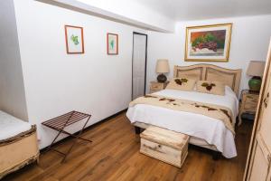 a white bedroom with a bed and two tables at Hotel Boutique Raíces de Colchagua in Santa Cruz