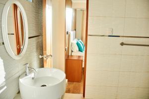 a white bathroom with a sink and a mirror at QAIPU HOTEL in Puquio +55 photos