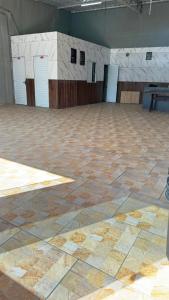 a large room with a stone floor and white doors at Top festas in Campinas