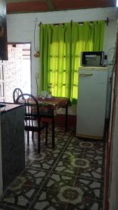 a kitchen with a table and a green curtain at Monoambiente LPS in Santiago del Estero