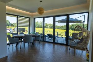 a dining room with a table with chairs and an umbrella at Domek dwóch jezior z jakuzzi, Chojno pojezierze Brodnickie in Chojno
