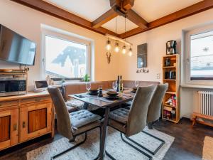 a dining room with a table and chairs and a tv at Alpenlodge Steiger in Neukirchen am Großvenediger