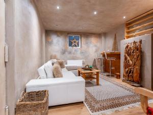 a living room with a white couch and a piano at Alpenlodge Steiger in Neukirchen am Großvenediger