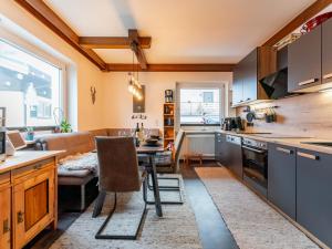 a kitchen and living room with a table and a couch at Alpenlodge Steiger in Neukirchen am Großvenediger