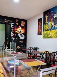 a restaurant with tables and chairs in a room at Mags GuestHouse in Praia