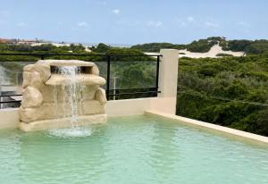 a fountain in a swimming pool with a waterfall at Laguna Sun Set in Salinópolis