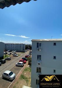 a building with cars parked in a parking lot at 08 - Apê próximo ao Metrô e Centro com Wi-Fi e Ar condionado in São Leopoldo