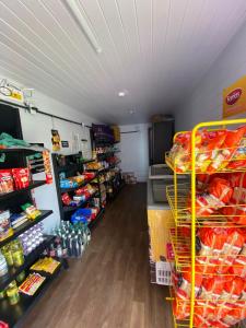 a grocery store aisle with shelves of food at 08 - Apê próximo ao Metrô e Centro com Wi-Fi e Ar condionado in São Leopoldo
