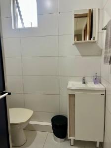 a white bathroom with a sink and a toilet at 08 - Apê próximo ao Metrô e Centro com Wi-Fi e Ar condionado in São Leopoldo +20 photos