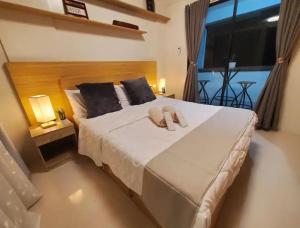 a bedroom with a large bed with two towels on it at The Coastal Luxe Suite in Samal +13 photos