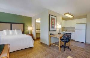 a hotel room with a bed and a desk and a kitchen at Extended Stay America Suites - Greensboro - Airport in Friendship +50 photos