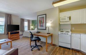 a hotel room with a desk and a bed at Extended Stay America Suites - Greensboro - Airport in Friendship