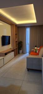 a living room with a couch and a television at Flat Praia da Costa in Vila Velha