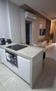 a kitchen with a stove and a counter top at Flat Praia da Costa in Vila Velha