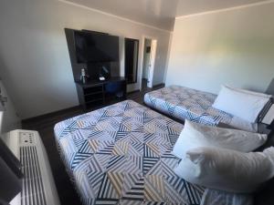 a hotel room with two beds and a flat screen tv at Studio 6 Elko, NV in Elko
