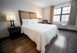 a bedroom with a large white bed and a window at Extended Stay America Suites - Boston - Woburn in Woburn +15 photos
