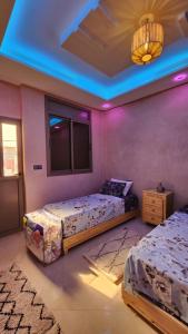 a bedroom with two beds and a blue ceiling at VibeLine Surf Camp in Tamraght Ouzdar