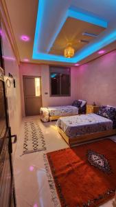 a room with two beds and a blue ceiling at VibeLine Surf Camp in Tamraght Ouzdar