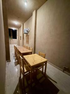 a dining room with wooden tables and chairs at Al-Sultan Hotel in Al Aqālitah