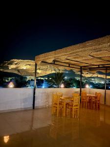a table and chairs on a patio at night at Al-Sultan Hotel in Al Aqālitah