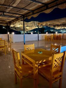 a wooden table and chairs under a tent at Al-Sultan Hotel in Al Aqālitah