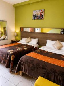 a hotel room with two beds in a room at Hotel Museo Carnaval in Huejotzingo