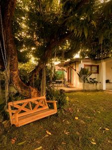 a wooden bench sitting under a tree in a yard at Casa Úrsula in Panama City