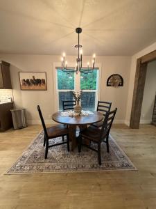 a dining room table with chairs and a chandelier at Home Town Mountain Lodging 2 in Darby