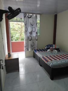 a bedroom with a bed and a window at Hotel GinaMar Ladrilleros in Buenaventura