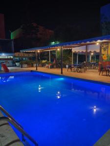 a swimming pool at night with a table and chairs at Villa Drayd in Ait Melloul