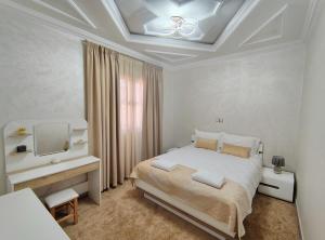 a white bedroom with a bed and a television at Villa Drayd in Ait Melloul +29 photos
