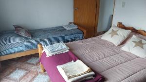 a bedroom with a twin bed with a purple blanket at Alojamiento LA ROSALIA in Yacimiento Río Turbio