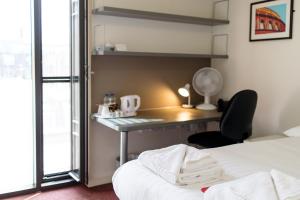 a bedroom with a desk and a bed with a chair at Princes Gardens in London