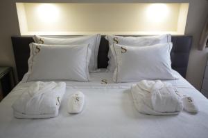 een bed met witte handdoeken en kussens erop bij Suites Guest House in Cascais