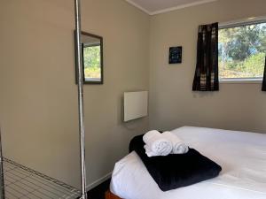 a bedroom with a bed with two towels on it at Tongariro Holiday Park in Tongariro
