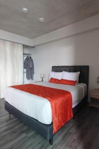 a bedroom with a large bed with a red blanket at Studio en piso 29 Secrt Sabana in San José +38 photos