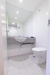 a bathroom with a sink and a toilet and a mirror at Princes Gardens in London