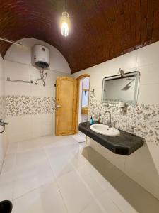 a bathroom with a sink and a mirror at Al-Sultan Hotel in Al Aqālitah +66 photos