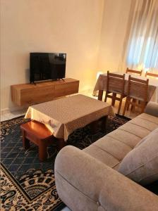 a living room with a couch and a tv at Le gîte in Tefeschoun