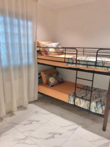 two bunk beds in a room with a window at Le gîte in Tefeschoun