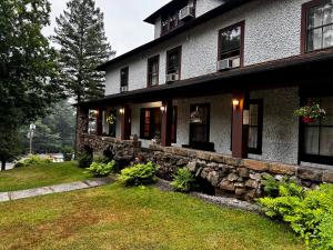 a large house with a stone wall in the yard at Rock Castle Resort in Lake George