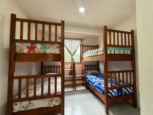 a bedroom with two bunk beds and a window at Casa Flor in San Antonio de la Cal