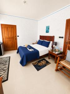 a bedroom with a bed with blue sheets and a chair at 1 Sol Dominicus Solo Adultos Habitación con Entrada Independiente y Baño Privado in Bayahibe
